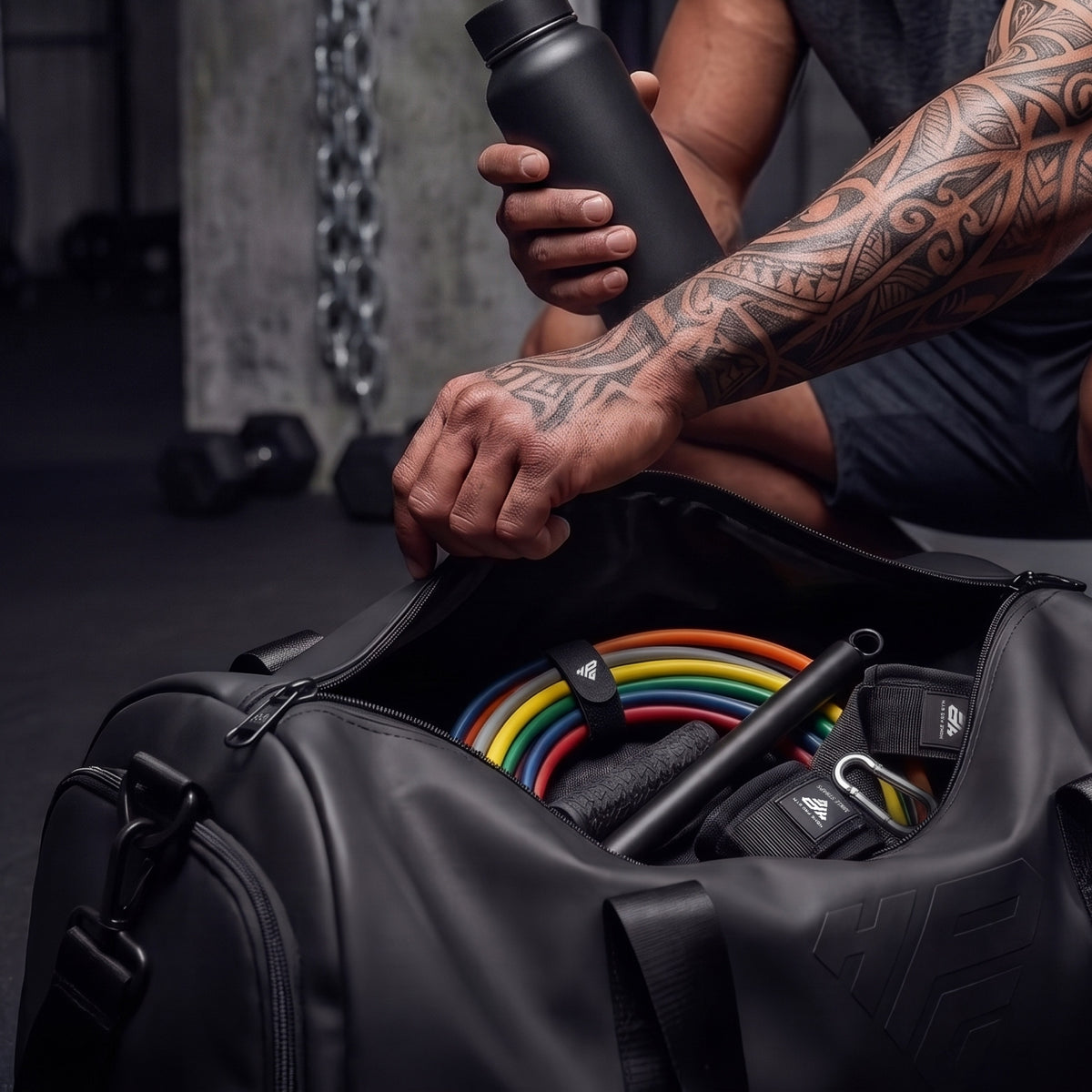 Bands bundled with a Clinch Band Storage Strap packed inside the GymRoam duffle bag next to the bar.