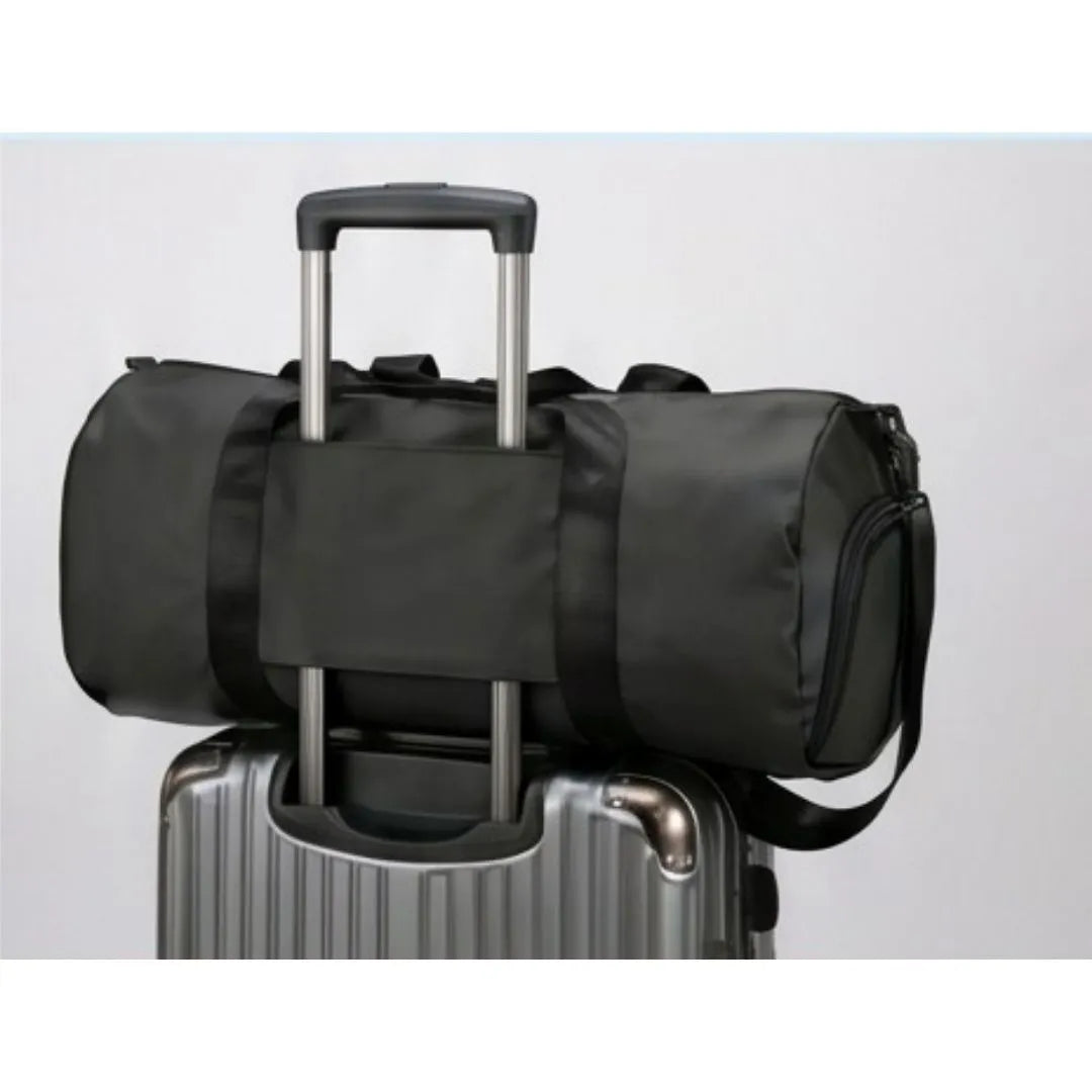 GymRoam 30L Duffle Bag secured on top of a rolling suitcase by its luggage strap