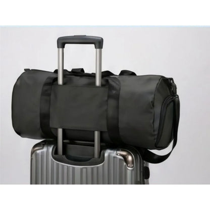 GymRoam 30L Duffle Bag secured on top of a rolling suitcase by its luggage strap