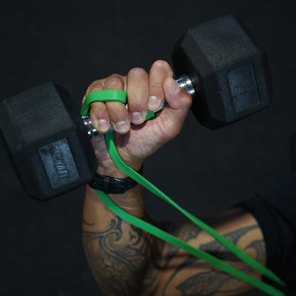 Green 35lbs Power Band looped around the hand while gripping a dumbbell, adding band resistance to the lift.