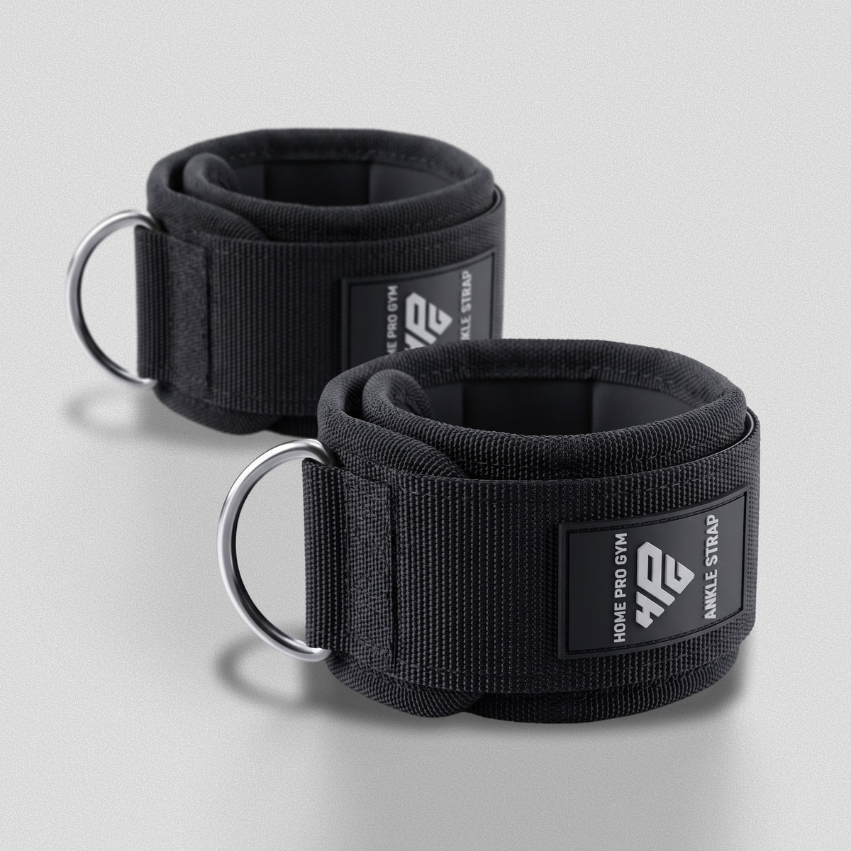 HomeProGym Ankle Straps: pair of padded black cuffs with hook-and-loop closure and steel D-rings.