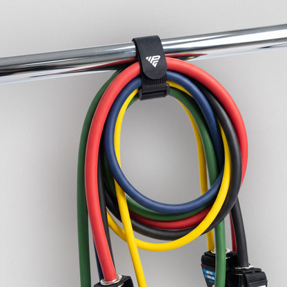Bundle of bands hanging from a rail by the Clinch Band Storage Strap, handles at the bottom.