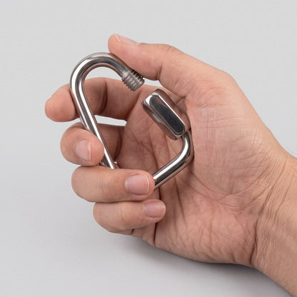 Hand holding a Power Band Carabiner, thumb on the screw gate.
