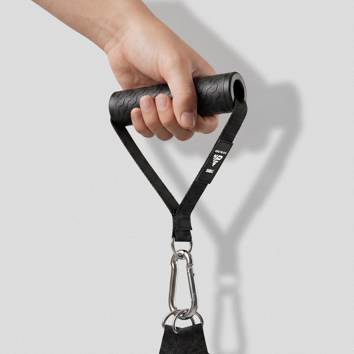 Hand gripping a Premium Handle with a carabiner clipped to its D-ring.