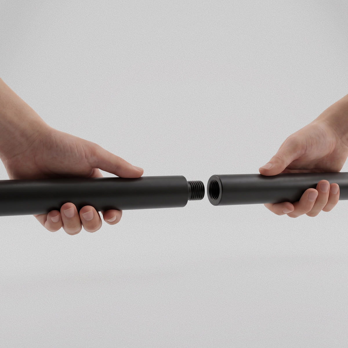Hands screwing the two halves of the Resistance Band Bar together at the threaded joint.