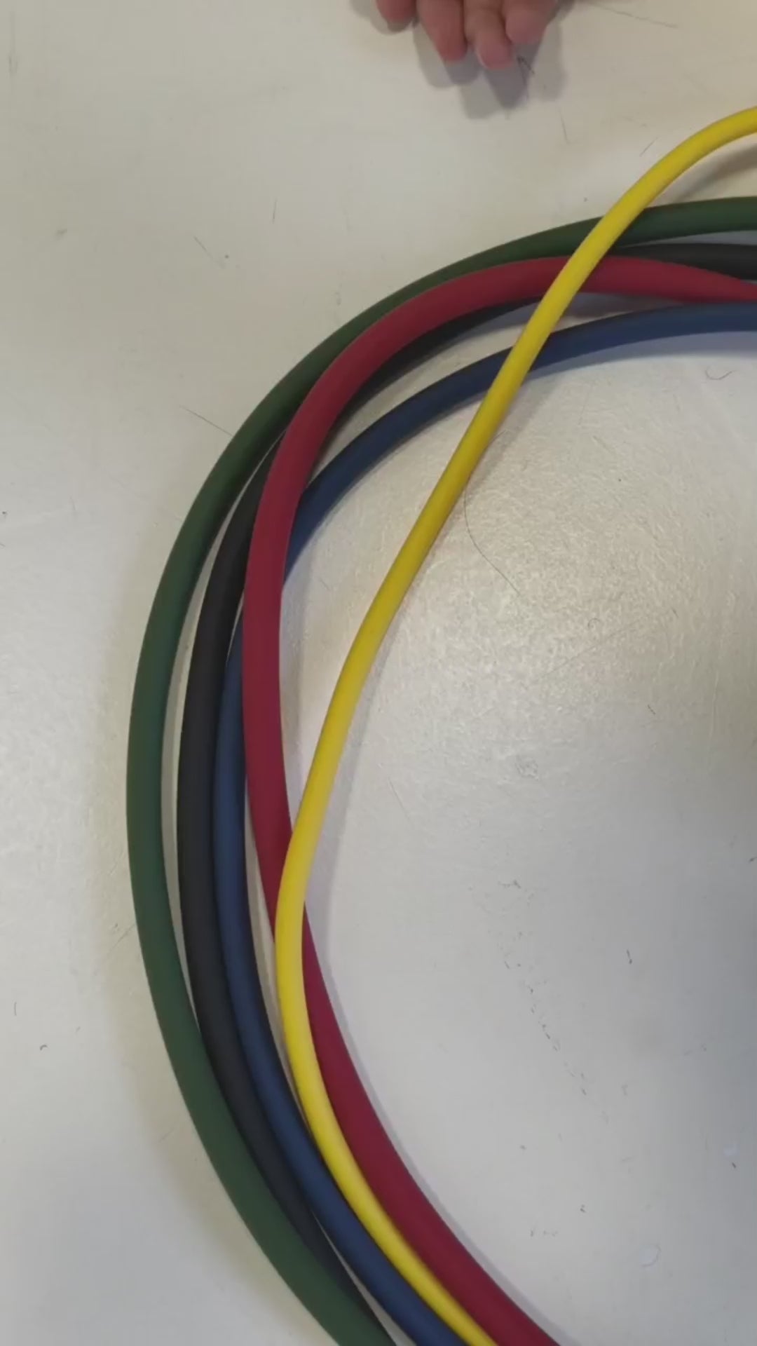 Video: hands bundling HomeProGym Resistance Bands and closing a Clinch Band Storage Strap around them