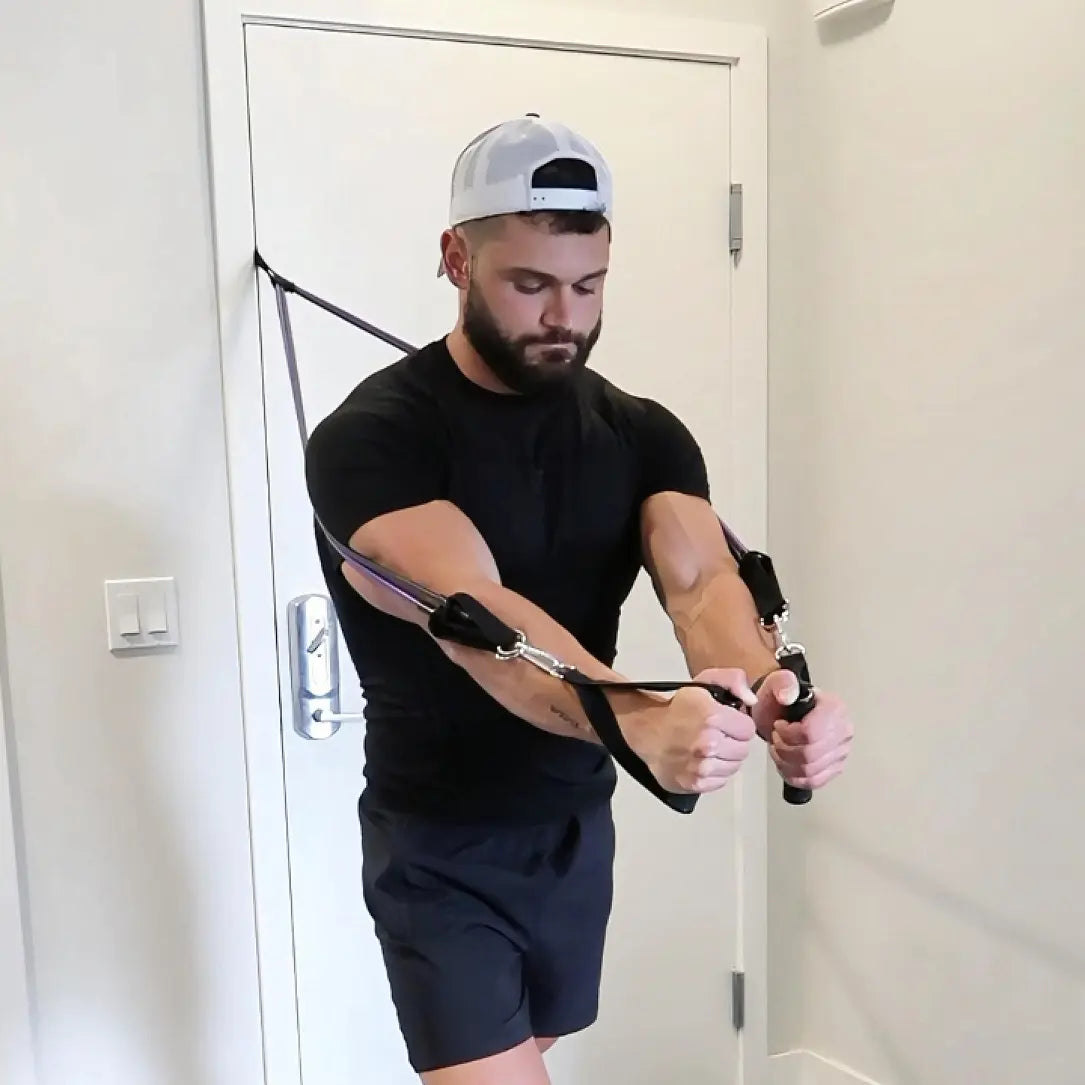Man using homeprogym powertube resistance bands against a white door