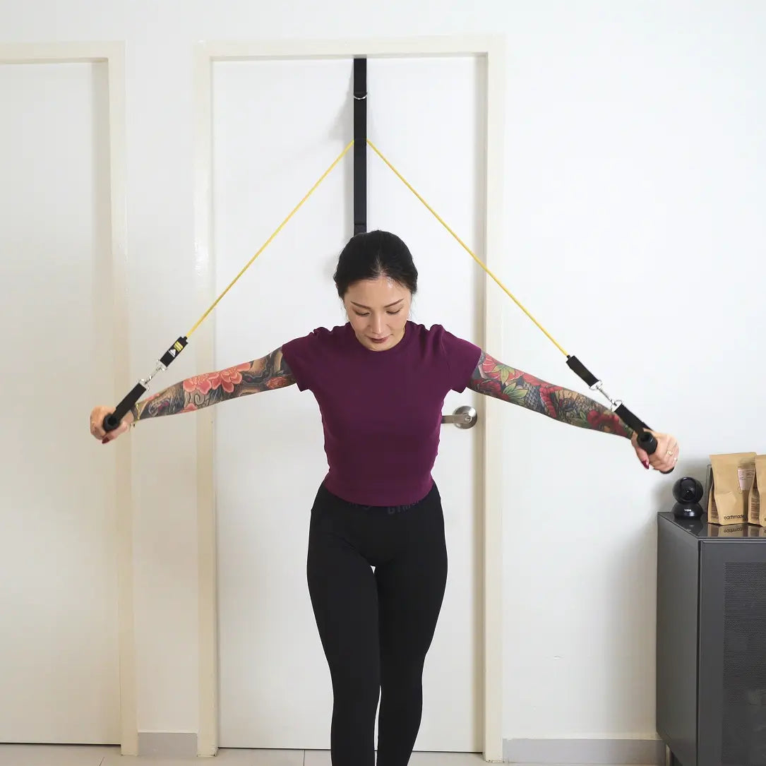 woman performing chest fly exercise with HomeProGym PowerTube stackable resistance bands at home